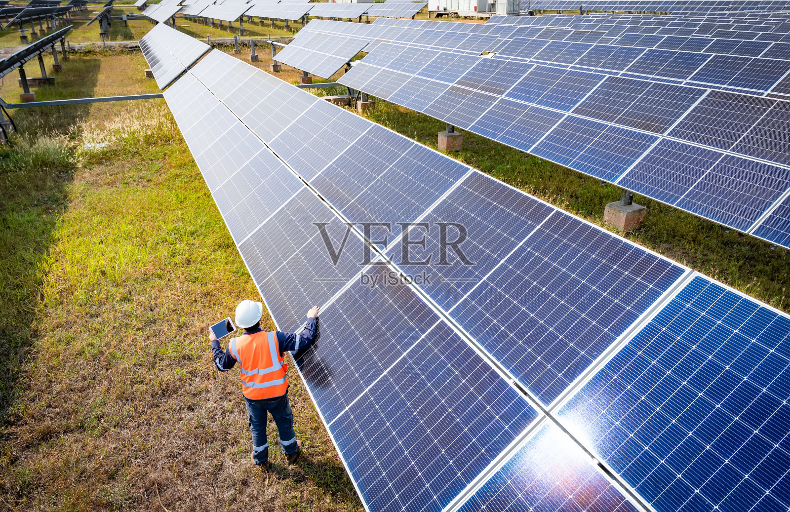 太阳能农场(太阳能电池板)与工程师检查系统的运行，节约世界能源的替代能源，光伏组件的清洁能源生产的想法照片摄影图片