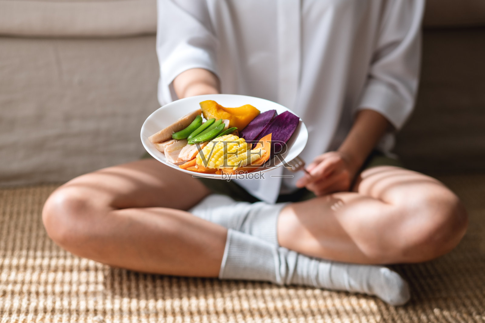 一个女人持有和吃蔬菜的特写图像，素食，清洁的食物，节食的概念照片摄影图片