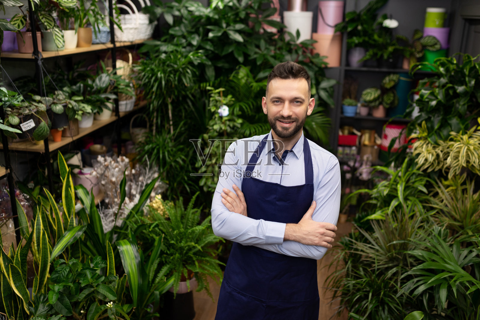 花卉仓库工人被盆栽植物包围照片摄影图片