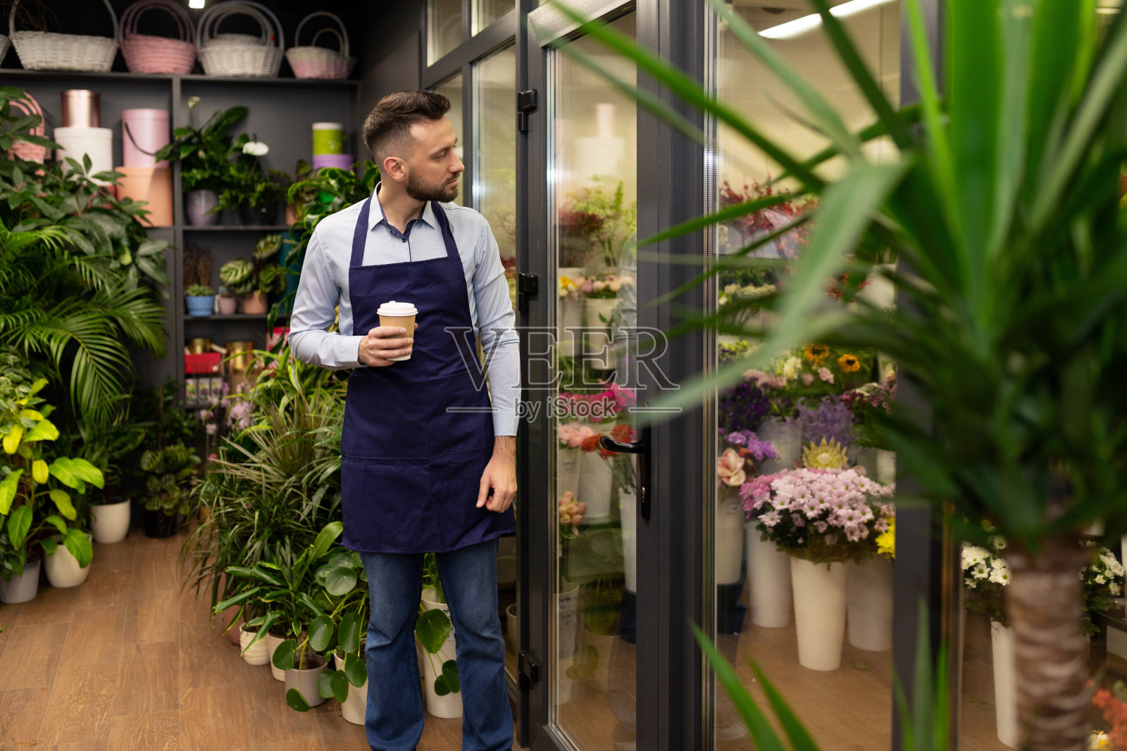在冰箱旁开了一家花店，旁边放着鲜花照片摄影图片
