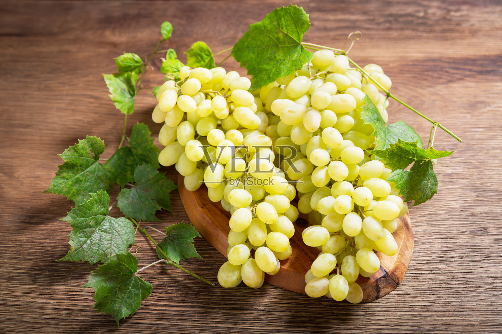 新鲜的葡萄和叶子放在木板上照片摄影图片