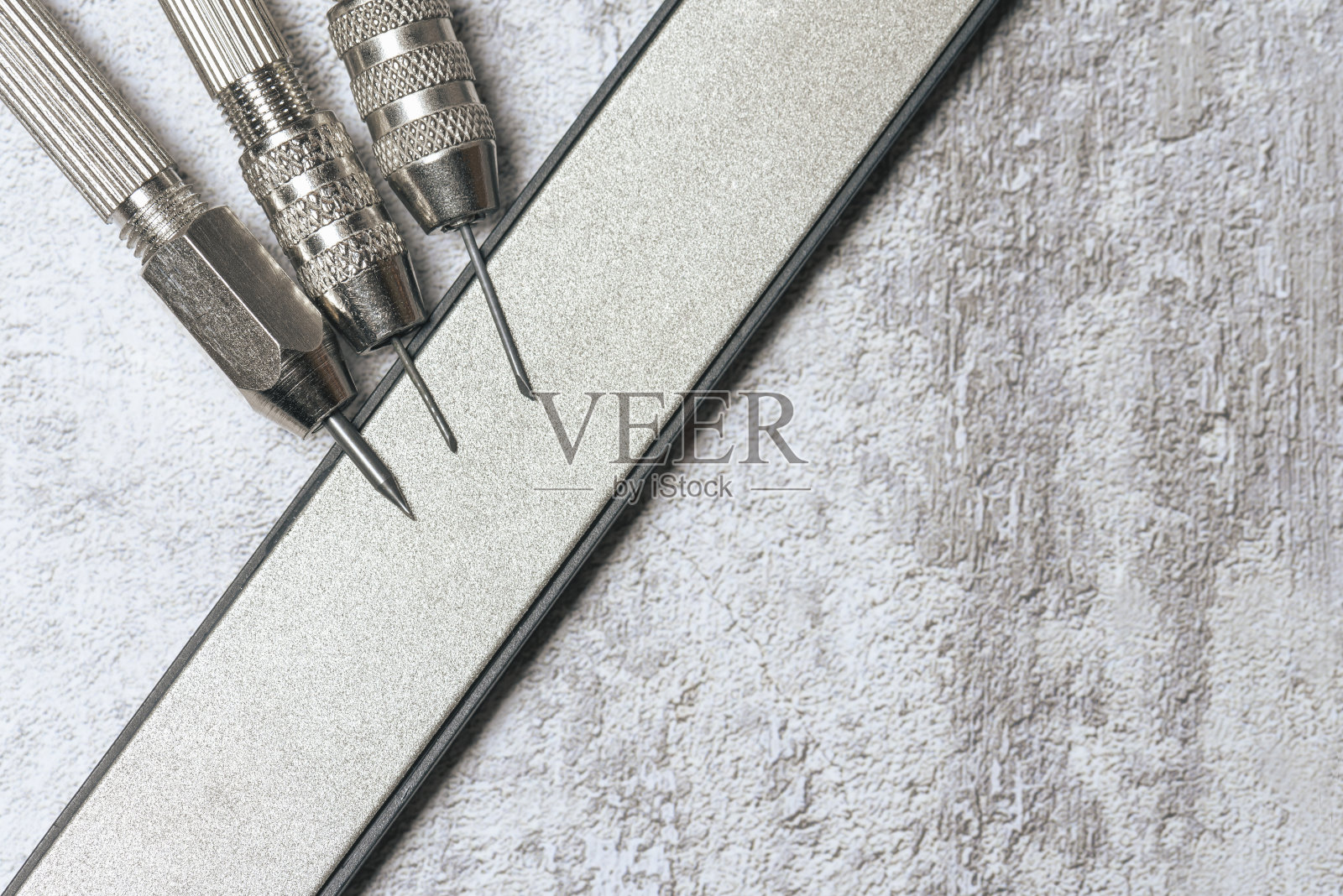 用于研磨的金刚石磨石上的锋利刮刀套装，用于硬币和考古物品的机械清洁。照片摄影图片