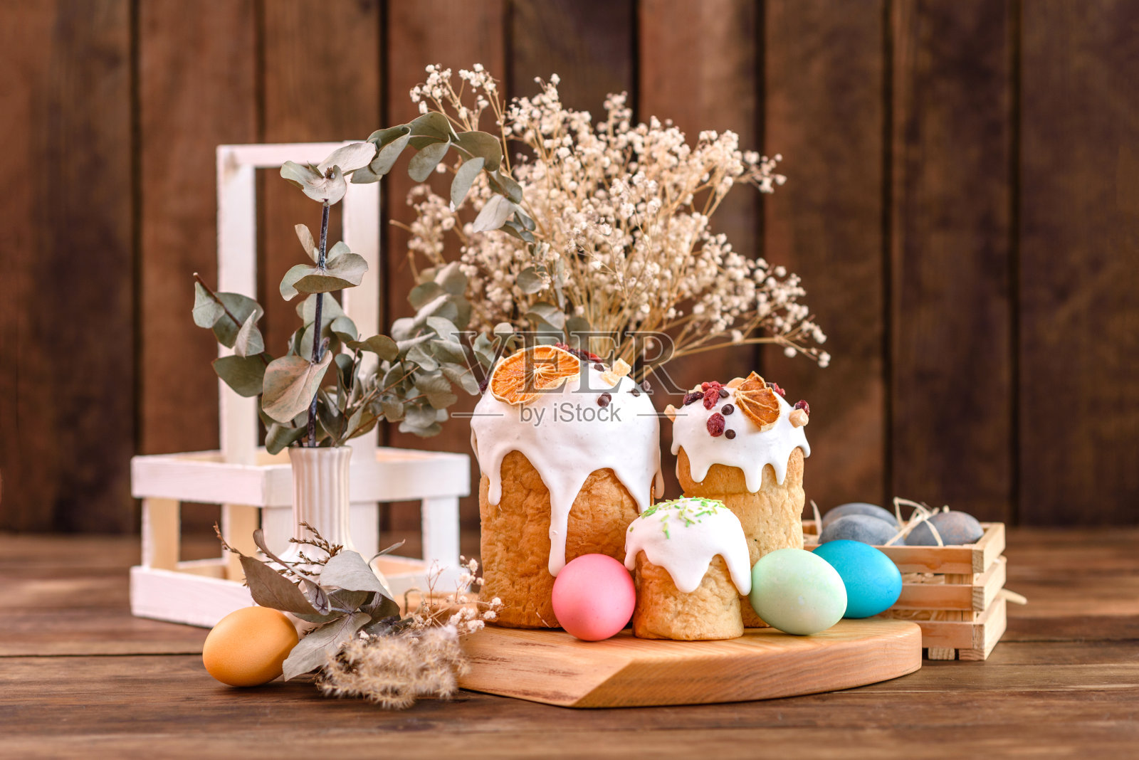 白釉节日蛋糕，坚果和葡萄干与复活节彩蛋在节日桌上照片摄影图片