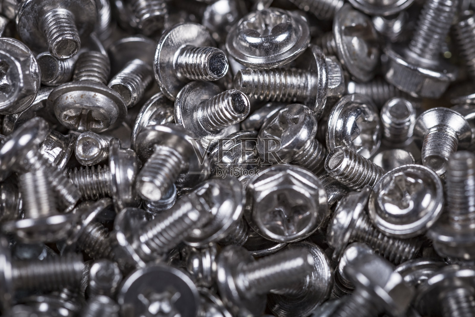 近距离观察五金店柜台上的铬机器螺丝。螺钉背景。照片摄影图片