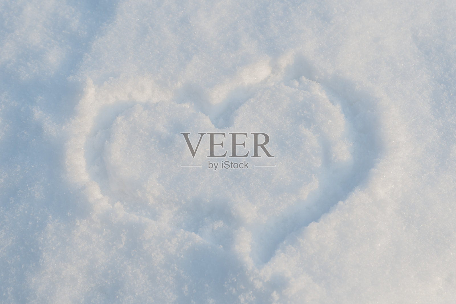 在雪地上手绘一个心形照片摄影图片