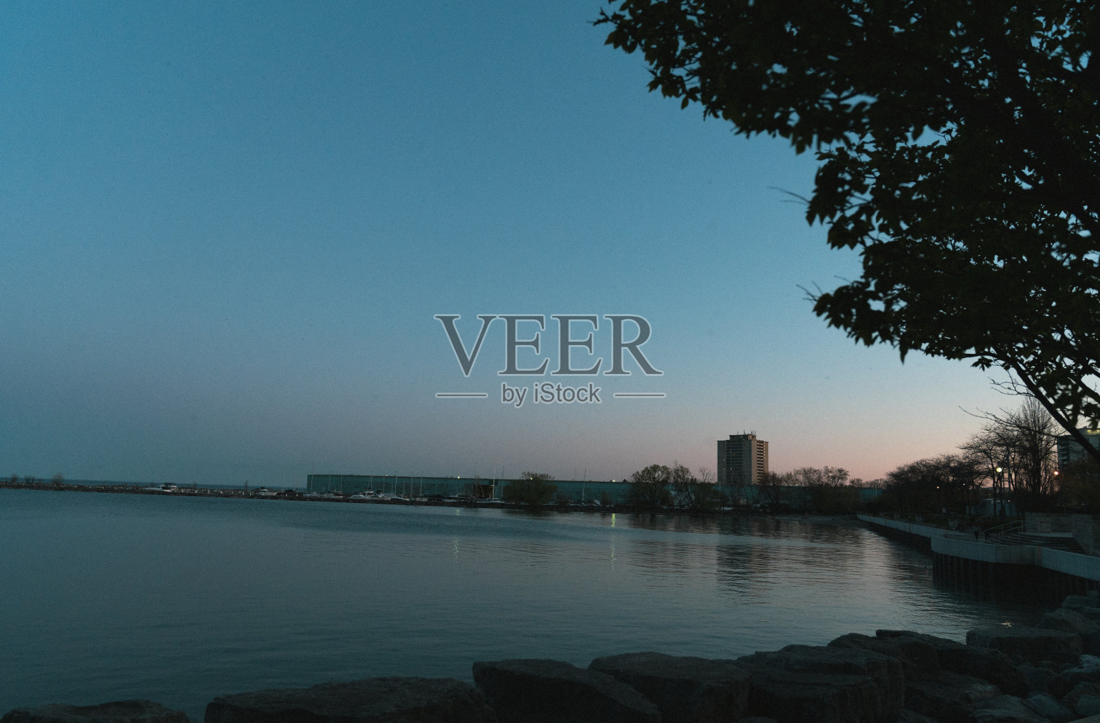 日落时分的码头，远处有一座建筑。照片摄影图片