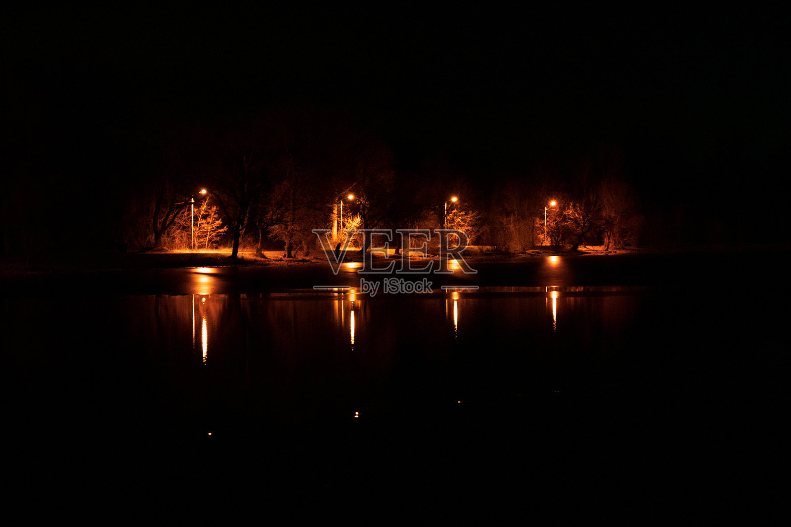 河对岸的夜景，灯火通明，森林密布照片摄影图片