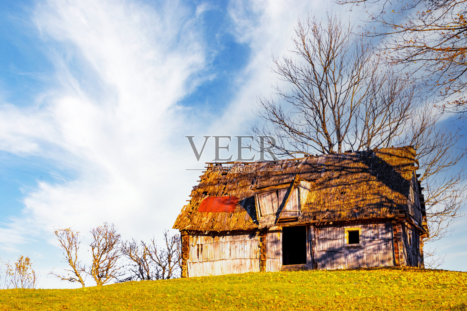 古老的木屋，建在群山环抱的草坡上照片摄影图片