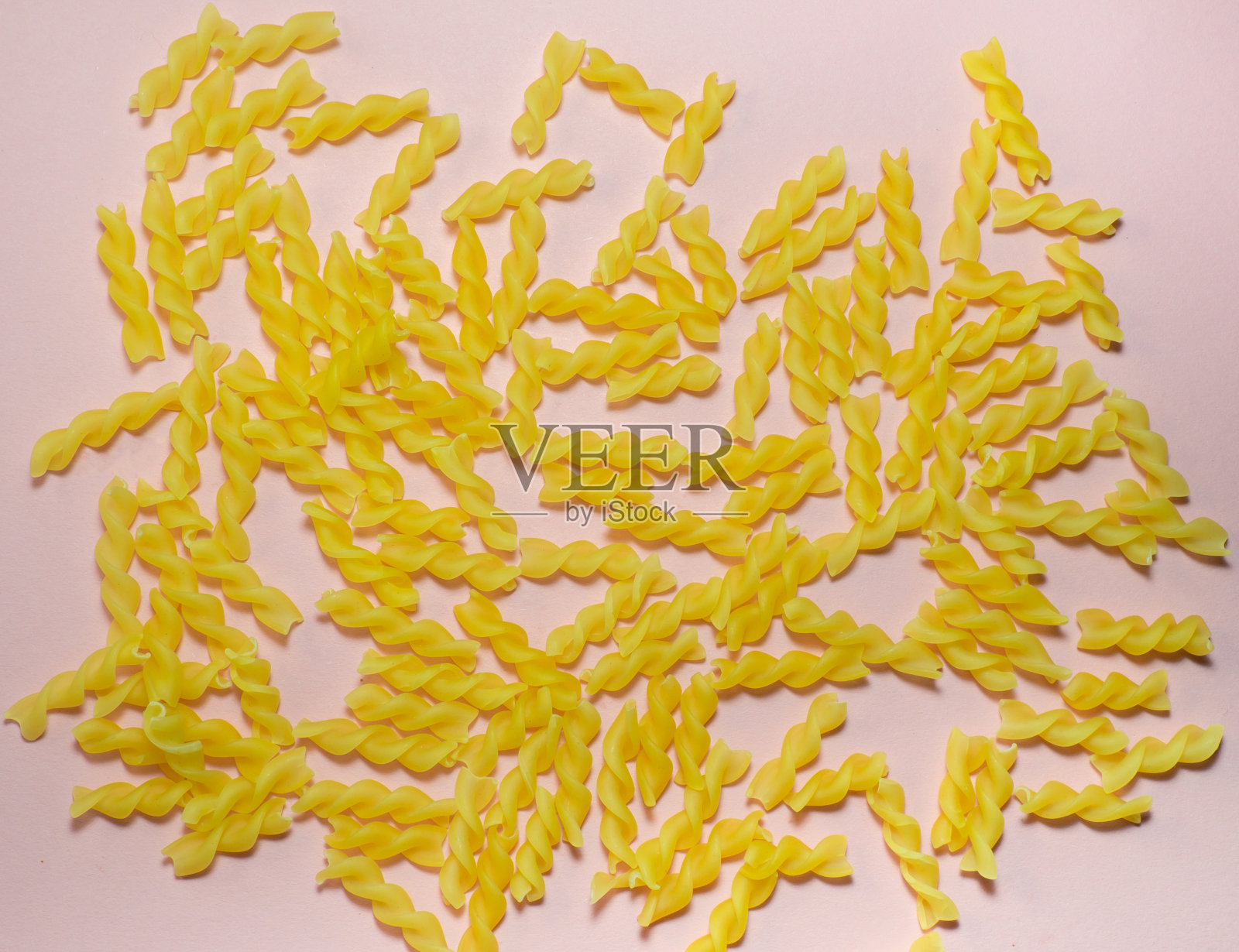 粉红色背景的螺旋意大利面照片摄影图片