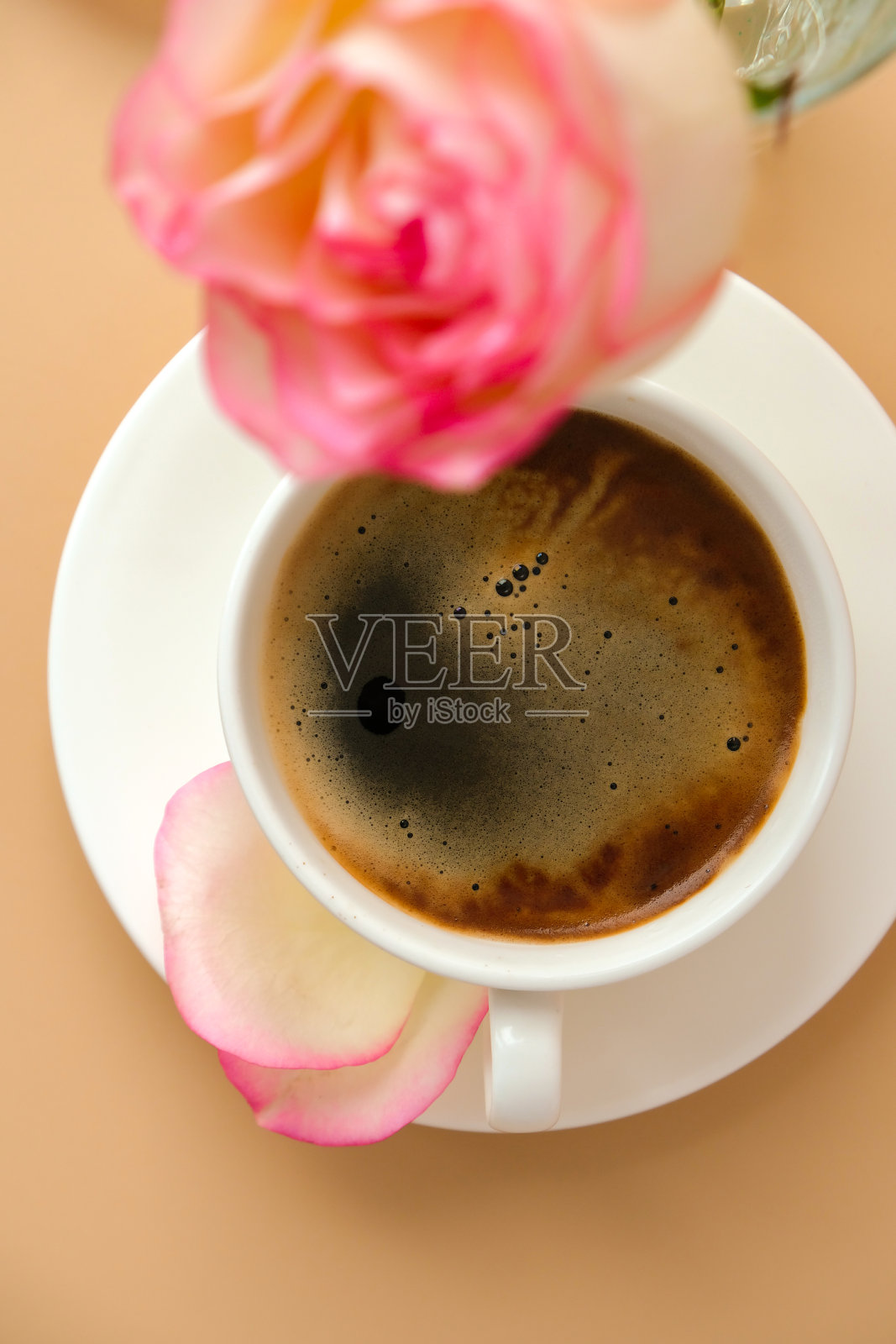 温柔的粉红色玫瑰花瓶与白色咖啡杯米色背景。最小的组合。浪漫的淡粉色玫瑰花。现代美学。中性地球音调。节日的早晨早餐照片摄影图片