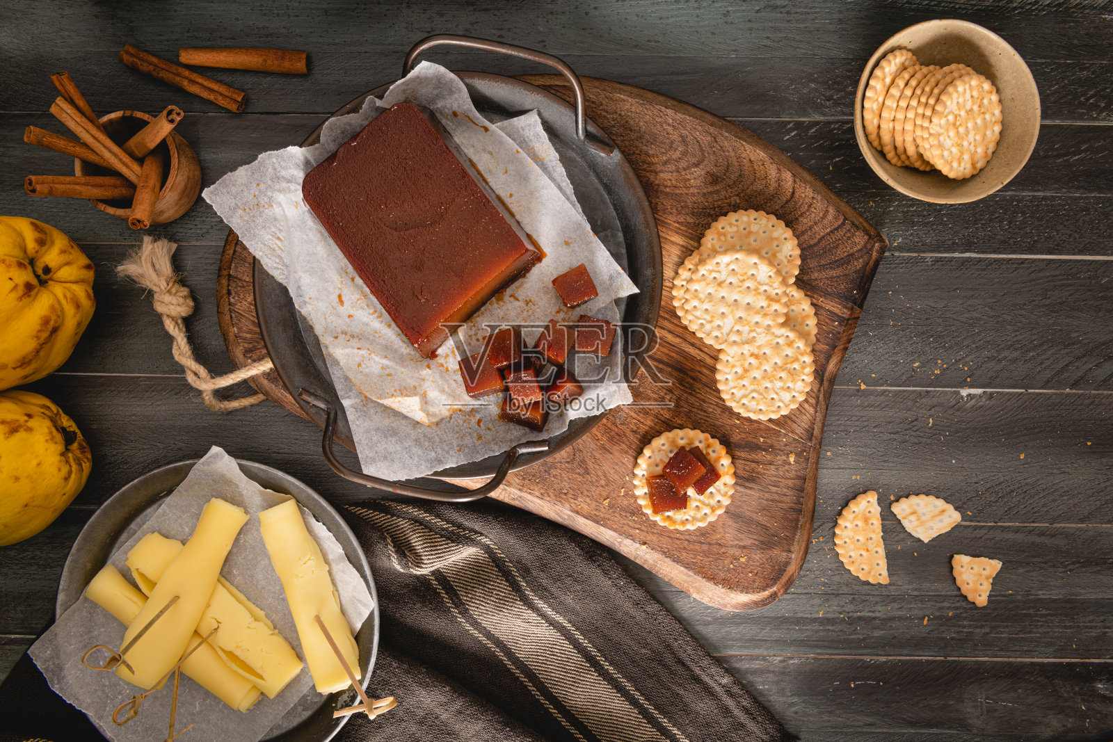榅桲芝士是用榅桲果的果肉做成的一种又甜又稠的果冻。厨房柜台上的饼干果酱。西班牙的大茴香酒照片摄影图片
