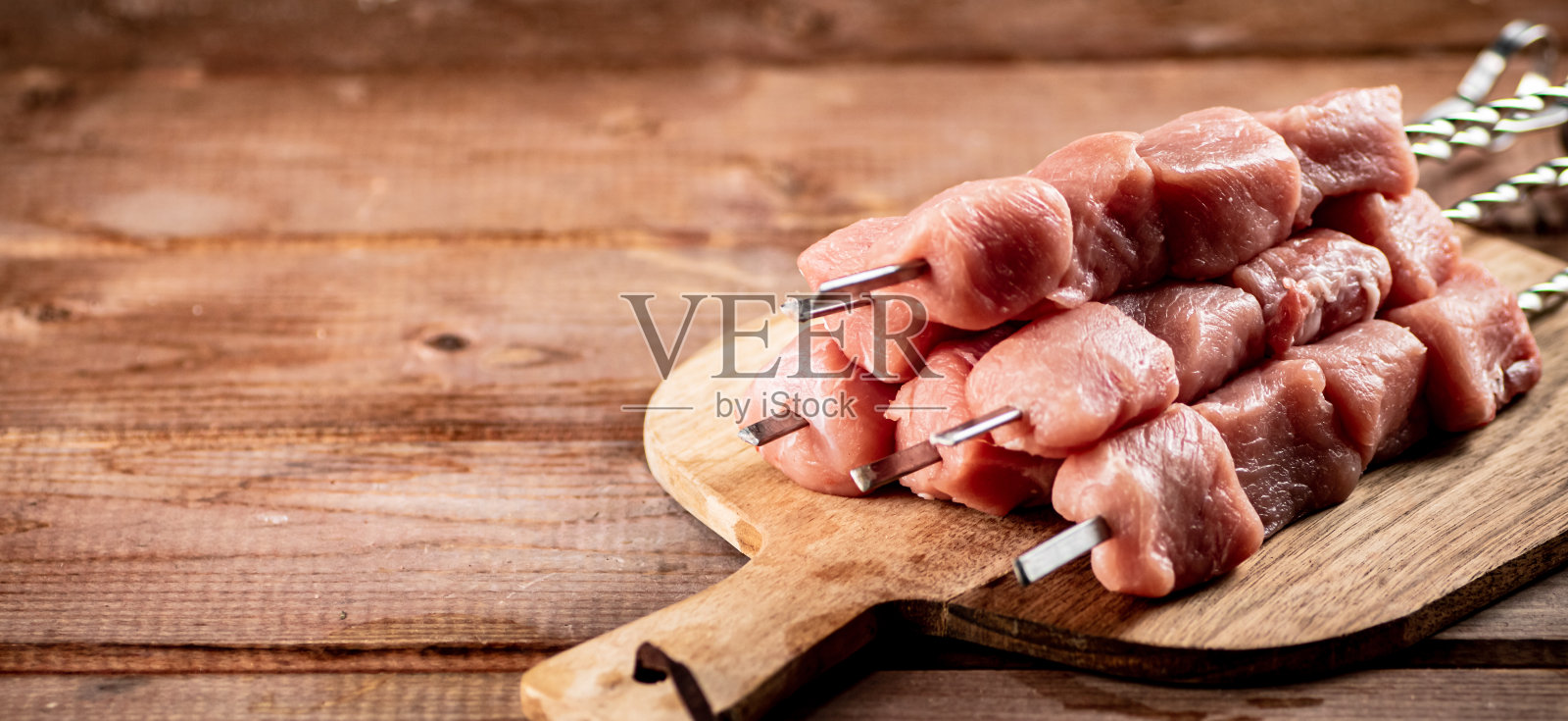 砧板上的生猪肉串。照片摄影图片