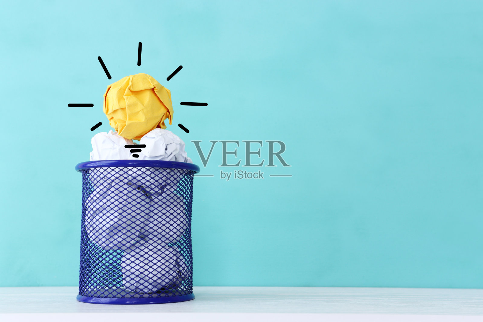 教育理念的形象。创意和创新。皱巴巴的纸就像蓝色背景下的灯泡照片摄影图片