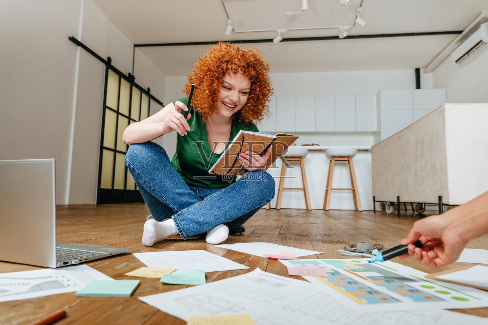 两个年轻女人坐在地板上讨论新项目照片摄影图片