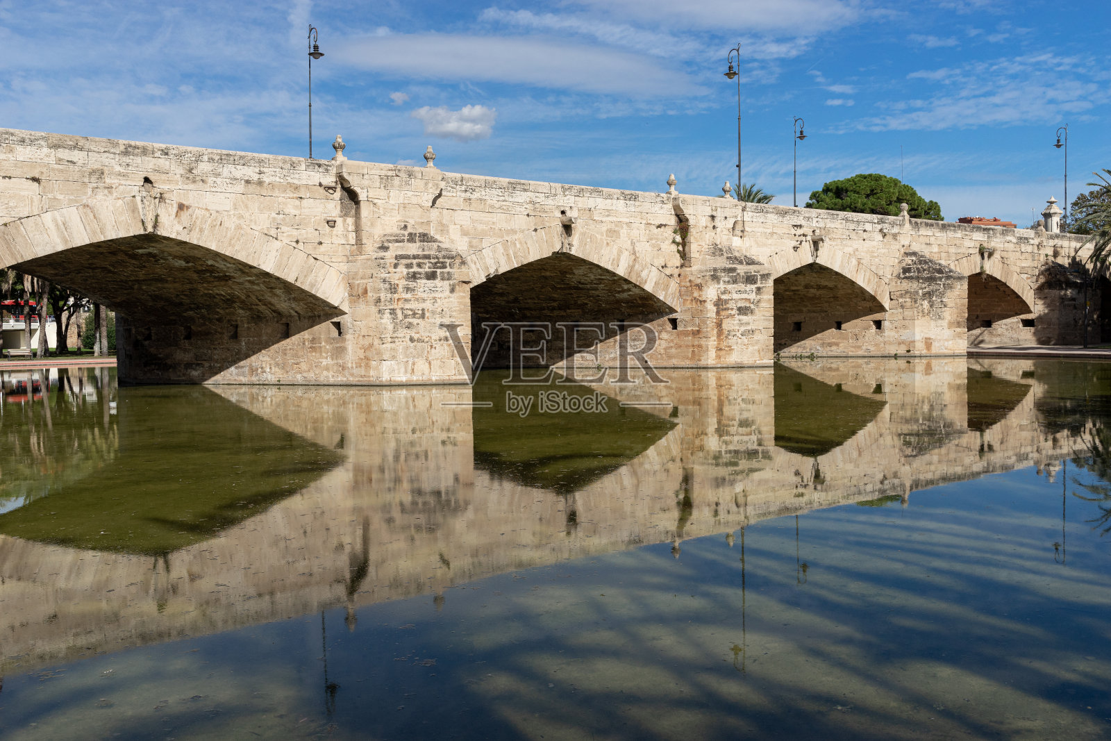 古老的石桥横跨古老的河床。西班牙巴伦西亚的图里亚河照片摄影图片