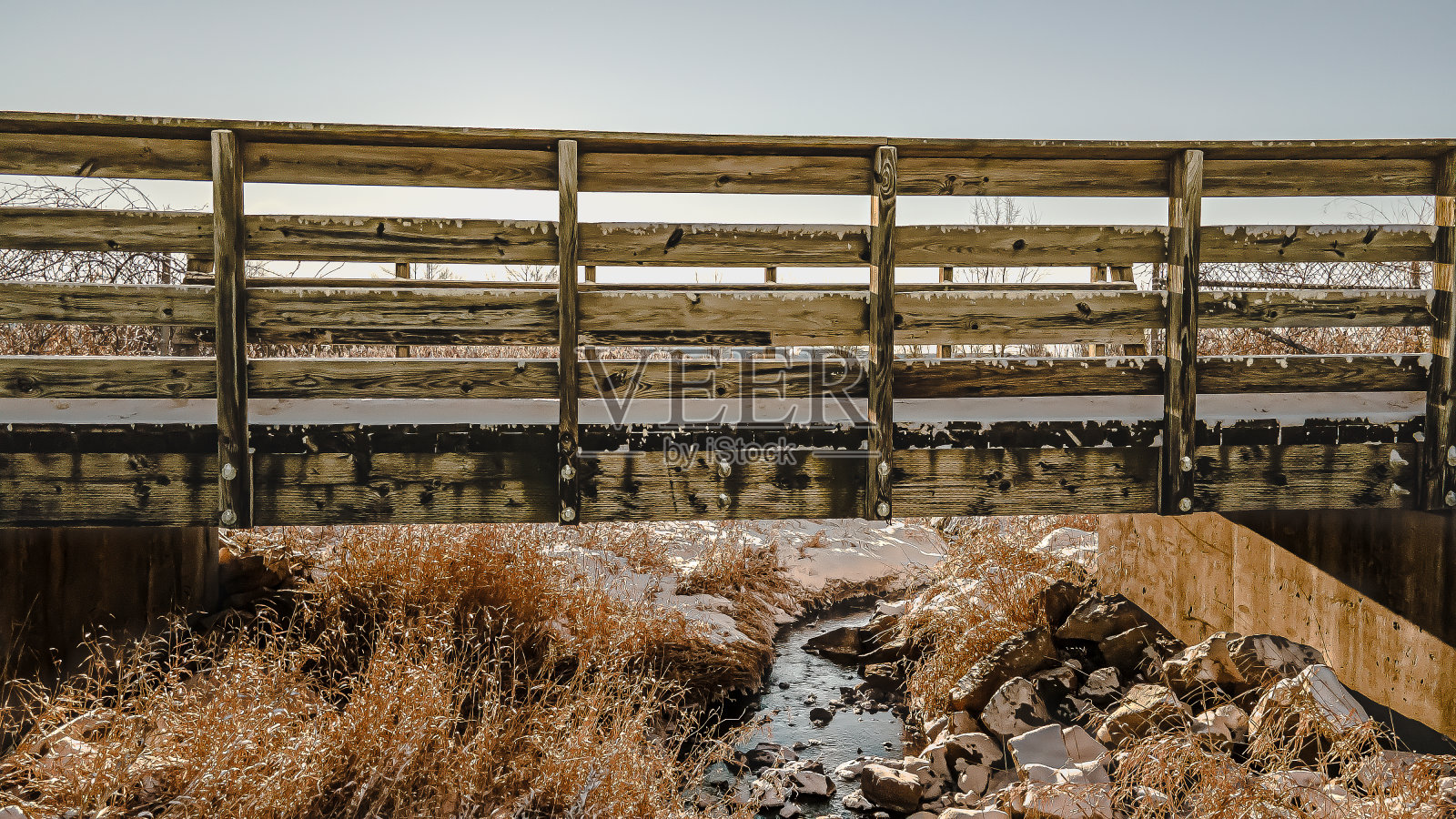 白雪覆盖的步行桥和温暖的夕阳的影子照片摄影图片