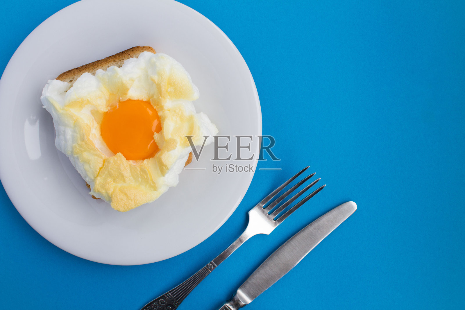 在蓝色背景的白色盘子上夹着鸡蛋的三明治。前视图。副本的空间。照片摄影图片