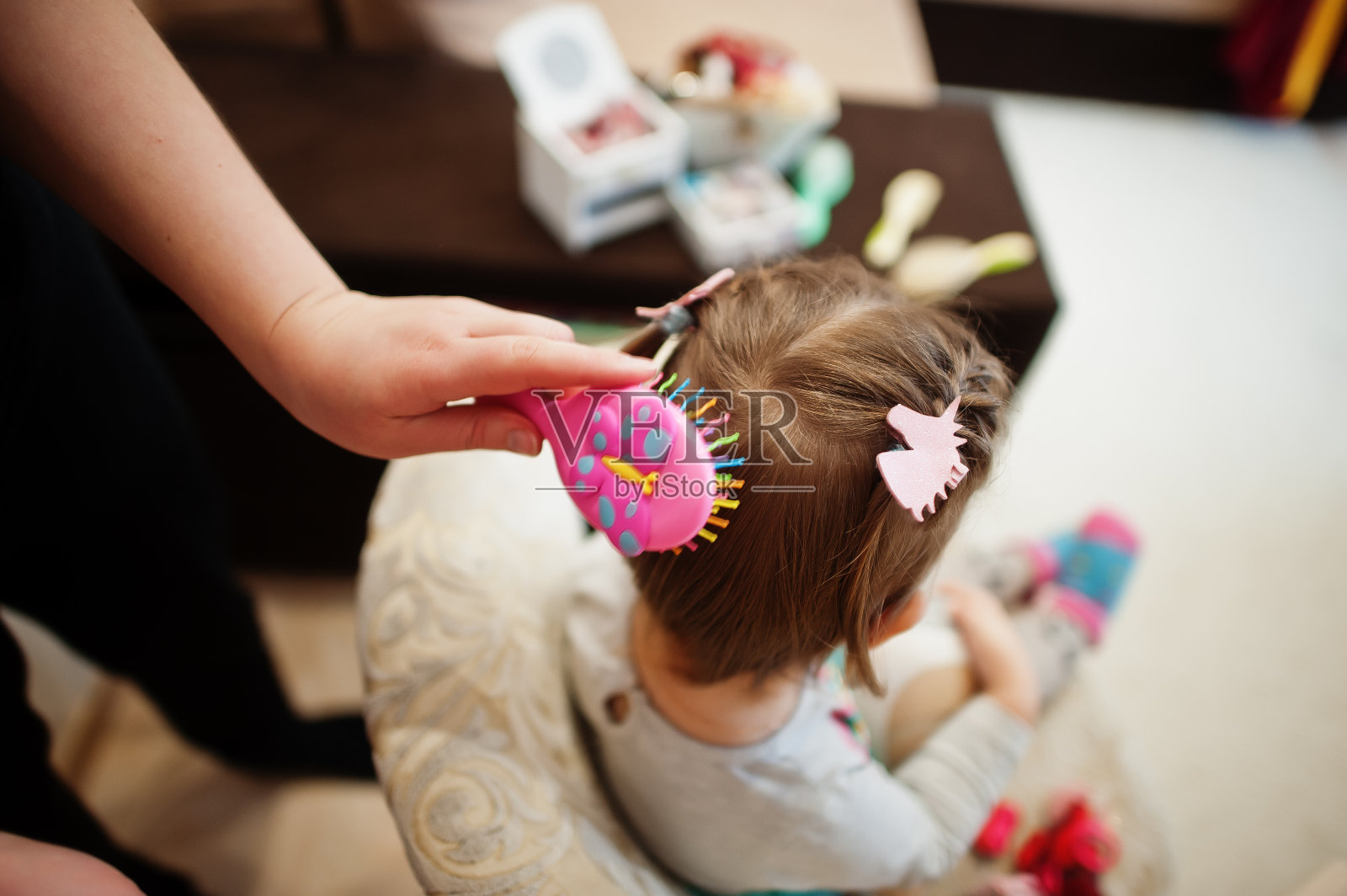 母女周末一起在家，妈妈为小女儿做发型。照片摄影图片