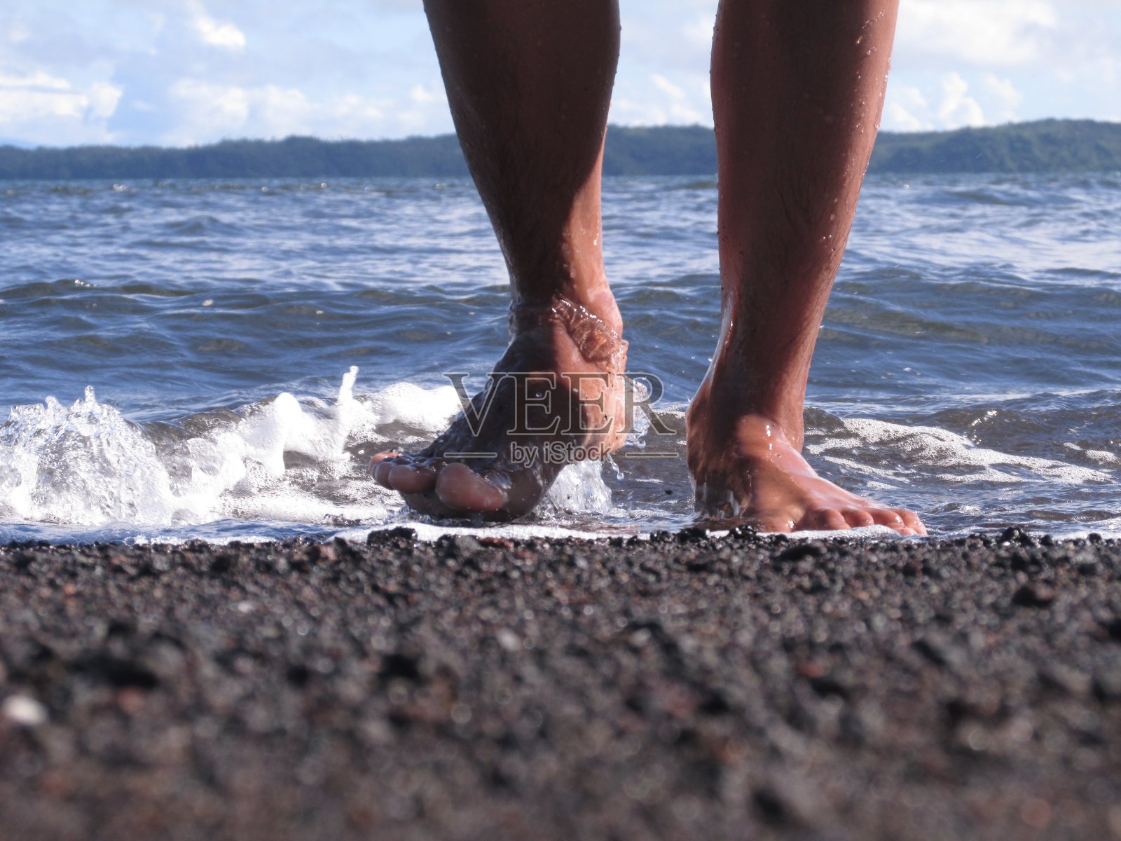 走在黑色的沙滩上照片摄影图片