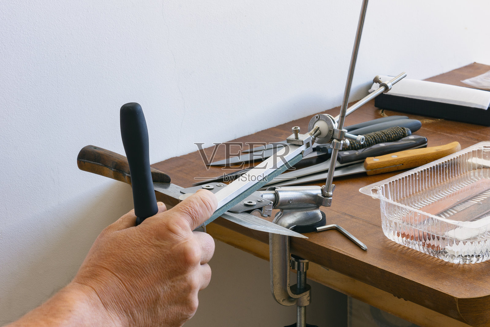 用手磨金属刀的机器照片摄影图片