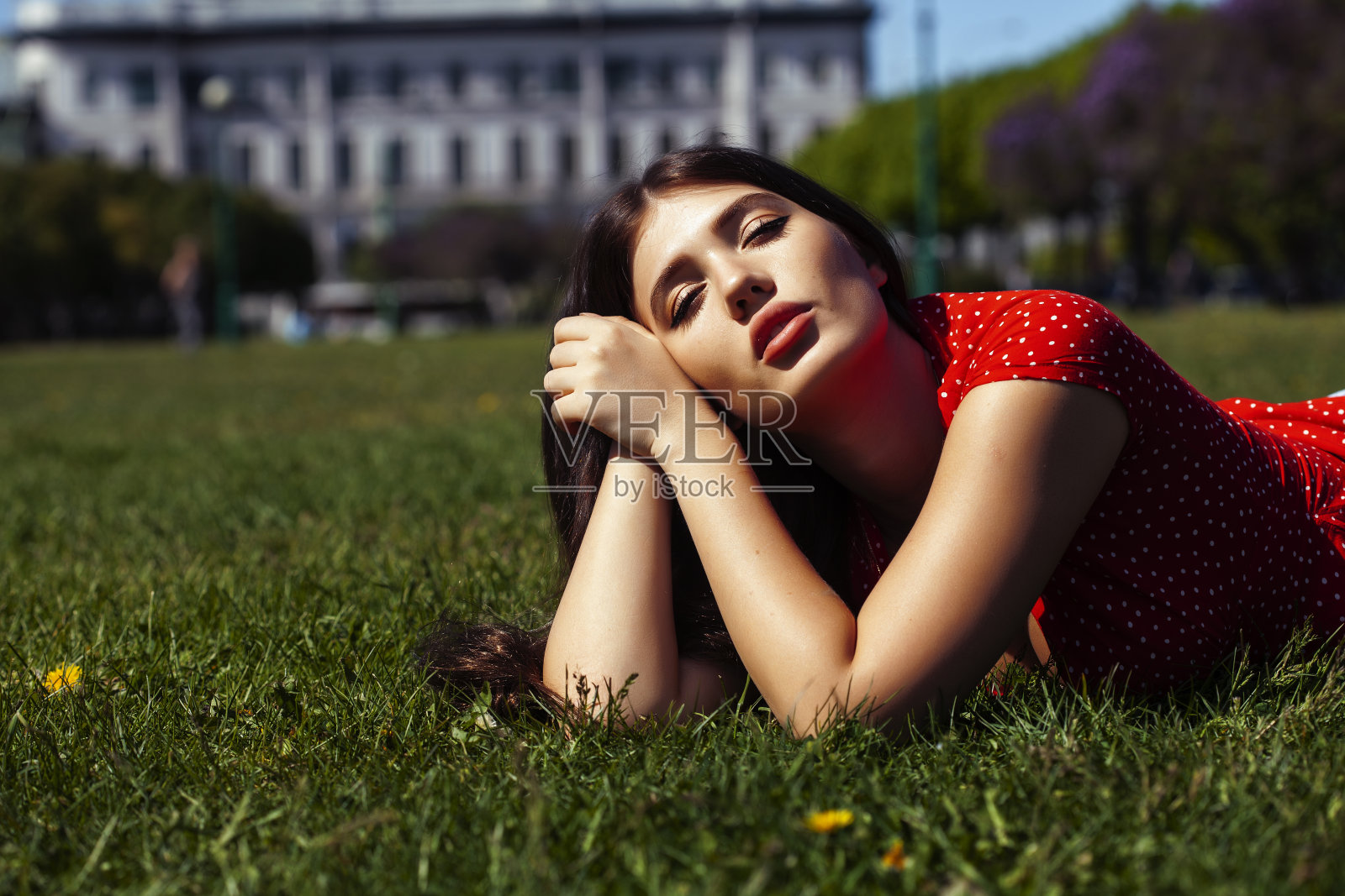 漂亮的年轻女子穿着红色的衣服微笑着愉快地在绿色的公园在夏天阳光明媚的日子，生活方式的人的概念照片摄影图片