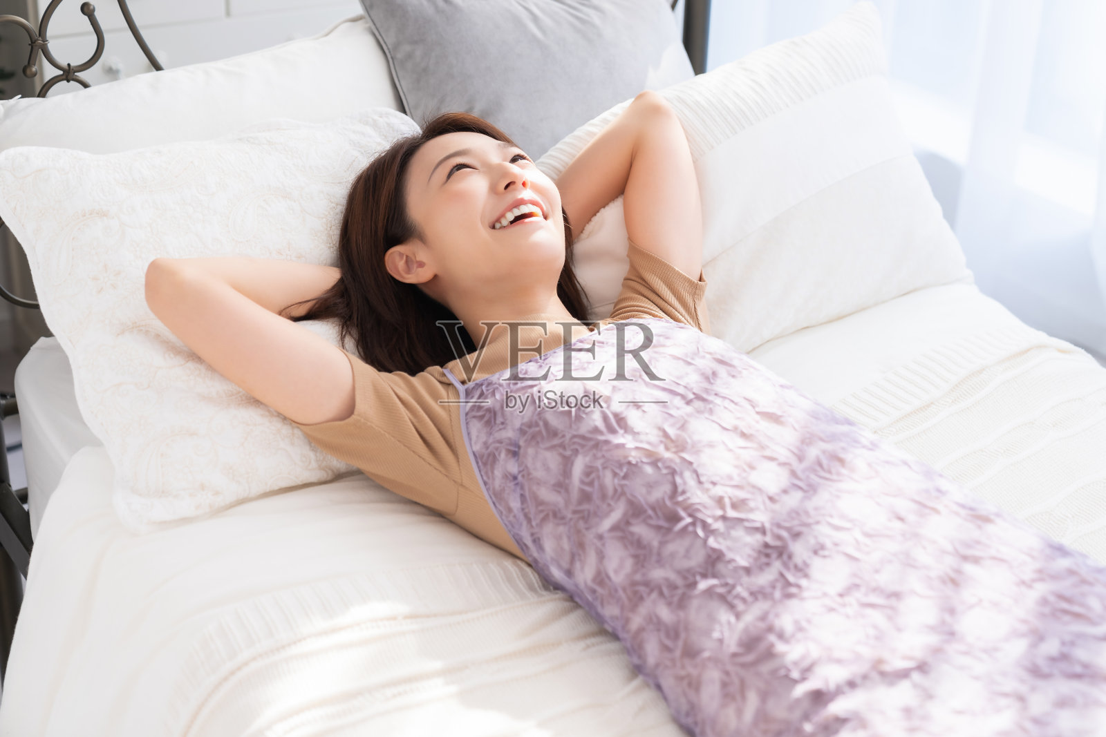 迷人的亚洲女人放松，床上照片摄影图片