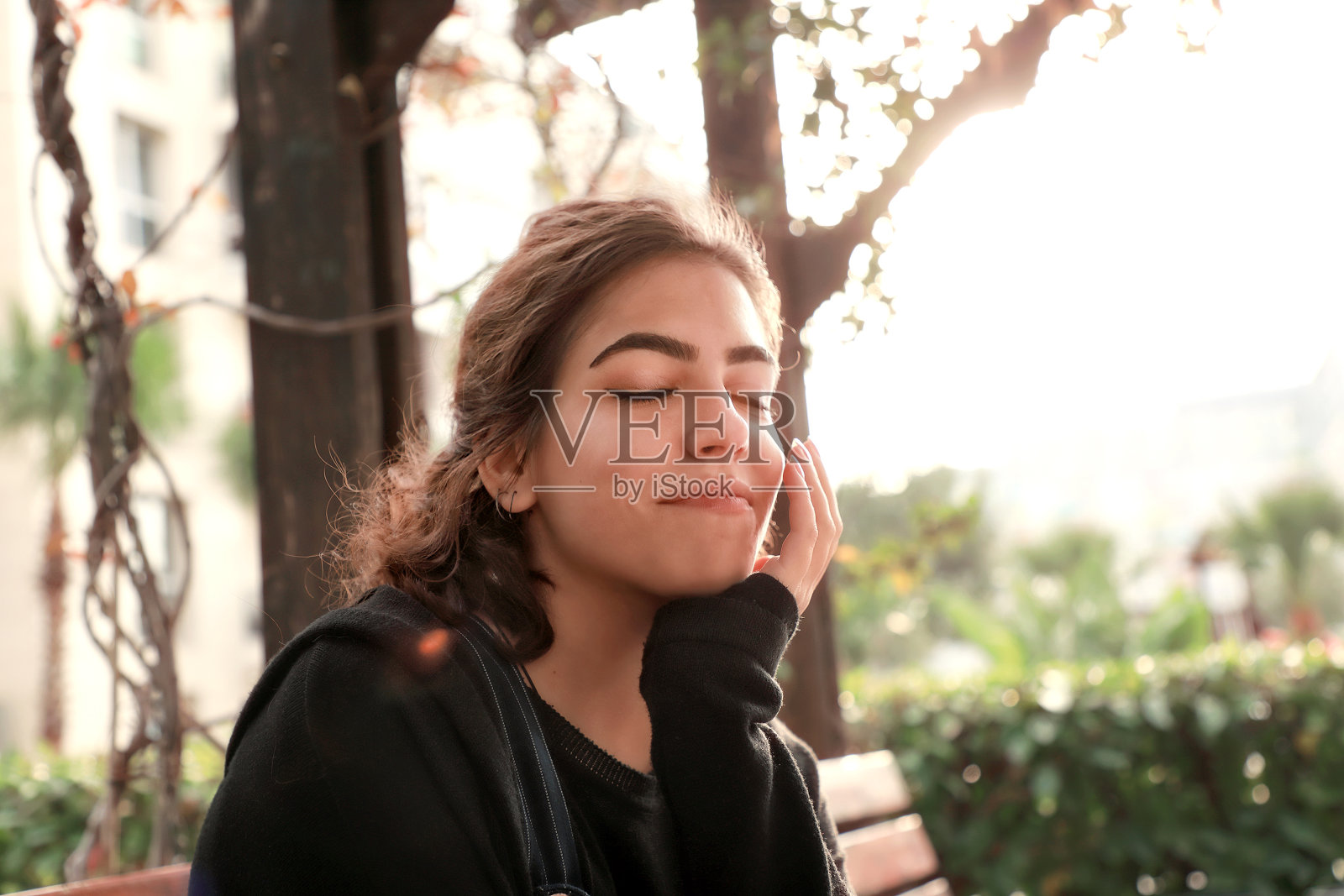 户外肖像的美丽快乐年轻黑发女子在阳光明媚的花园照片摄影图片