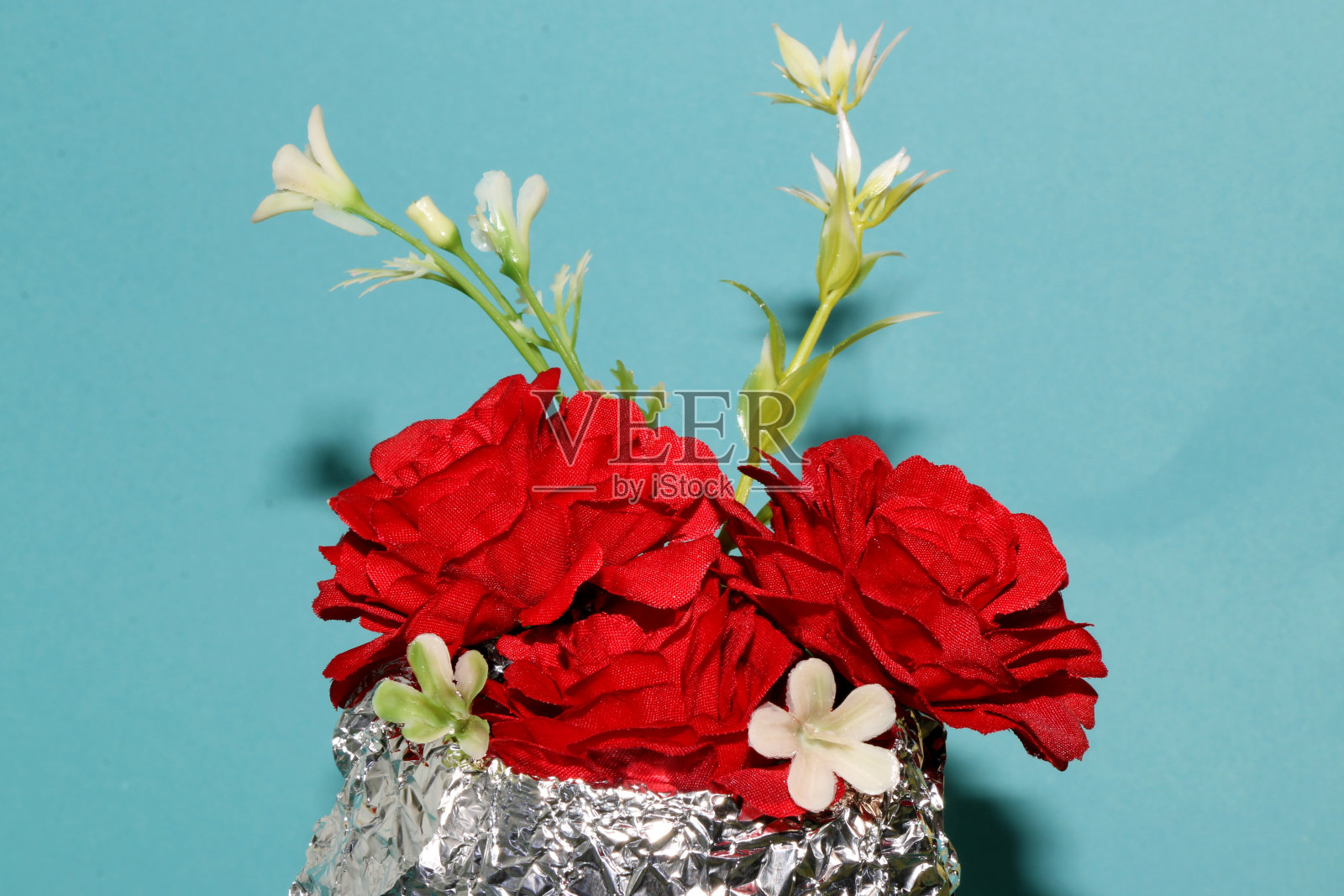 红色和白色的花在一个蓝色背景的箔罐照片摄影图片
