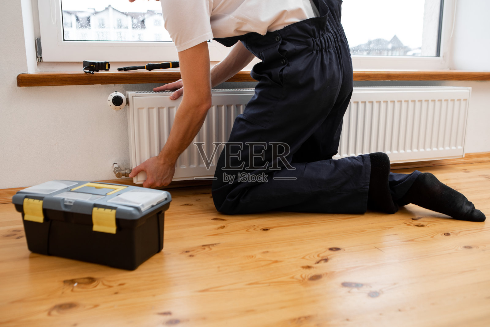 维修暖气片特写。修理暖气片用扳手。从散热器中取出空气照片摄影图片