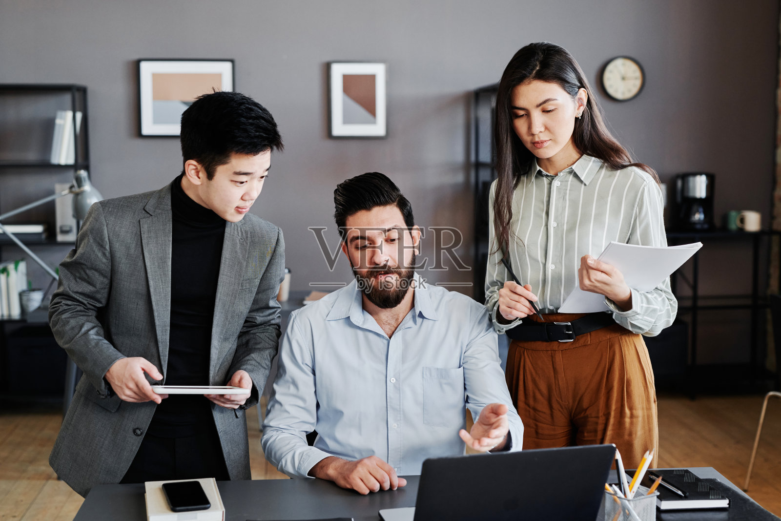 两个男人和一个女人一起研究新的投资项目，看着笔记本电脑屏幕讨论照片摄影图片