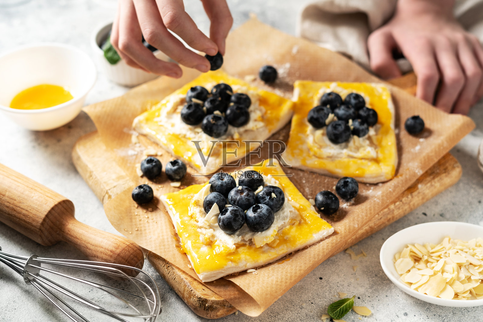 生松饼配芝士，奶油和蓝莓。制作美味的甜面包或迷你派的过程照片摄影图片