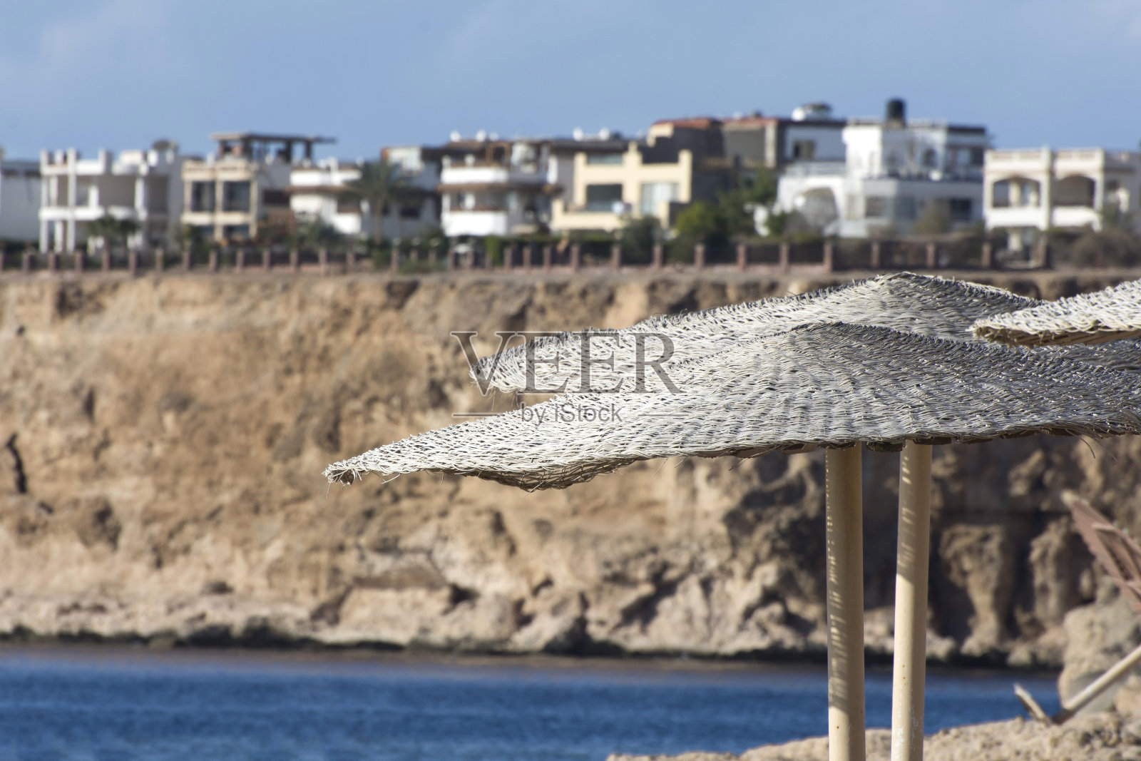 沙姆沙伊赫河堤上阳光下的雨伞。红海海滨胜地。照片摄影图片