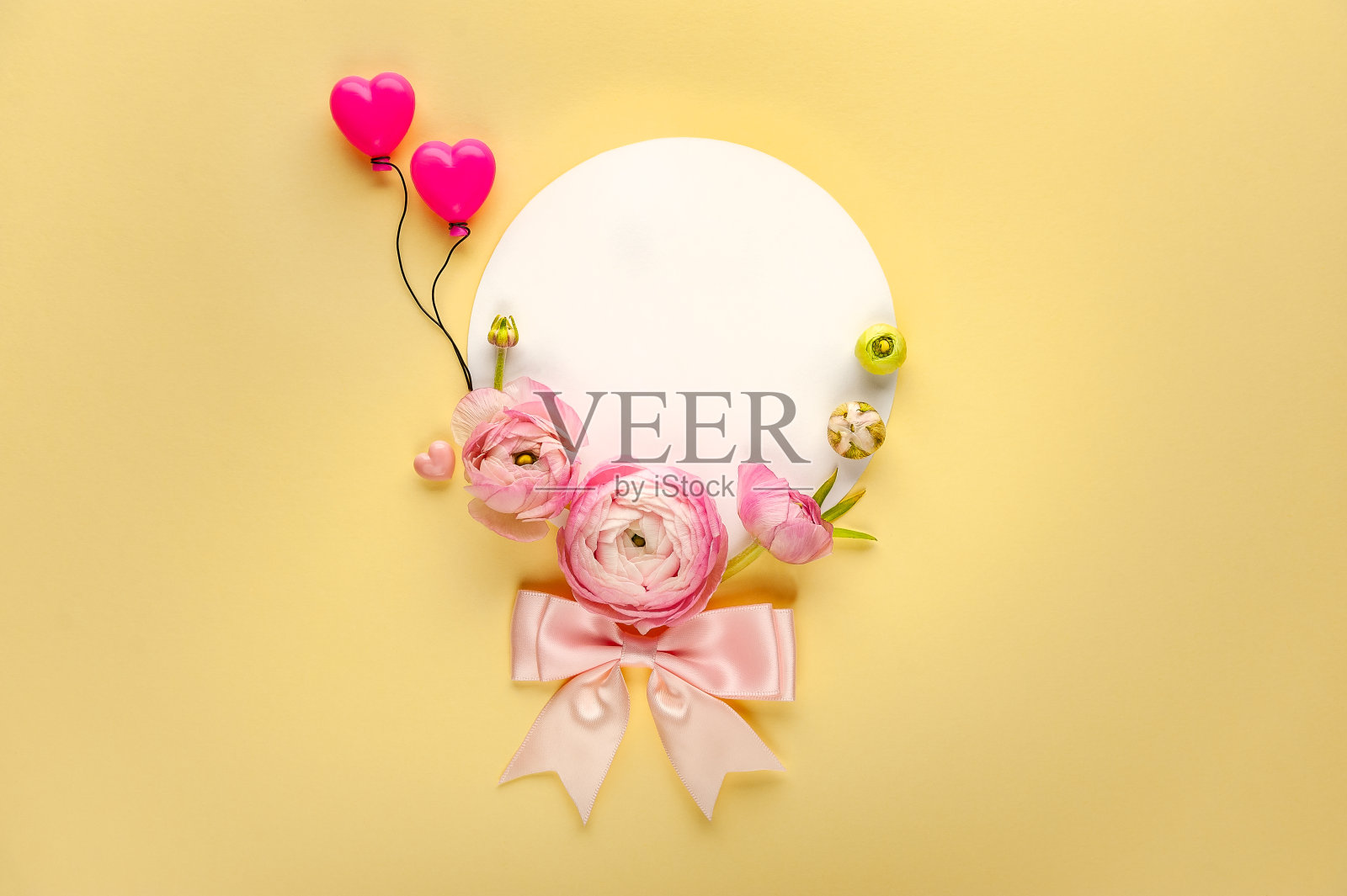 黄色背景上的空白明信片上装饰着粉红色的毛茛。照片摄影图片