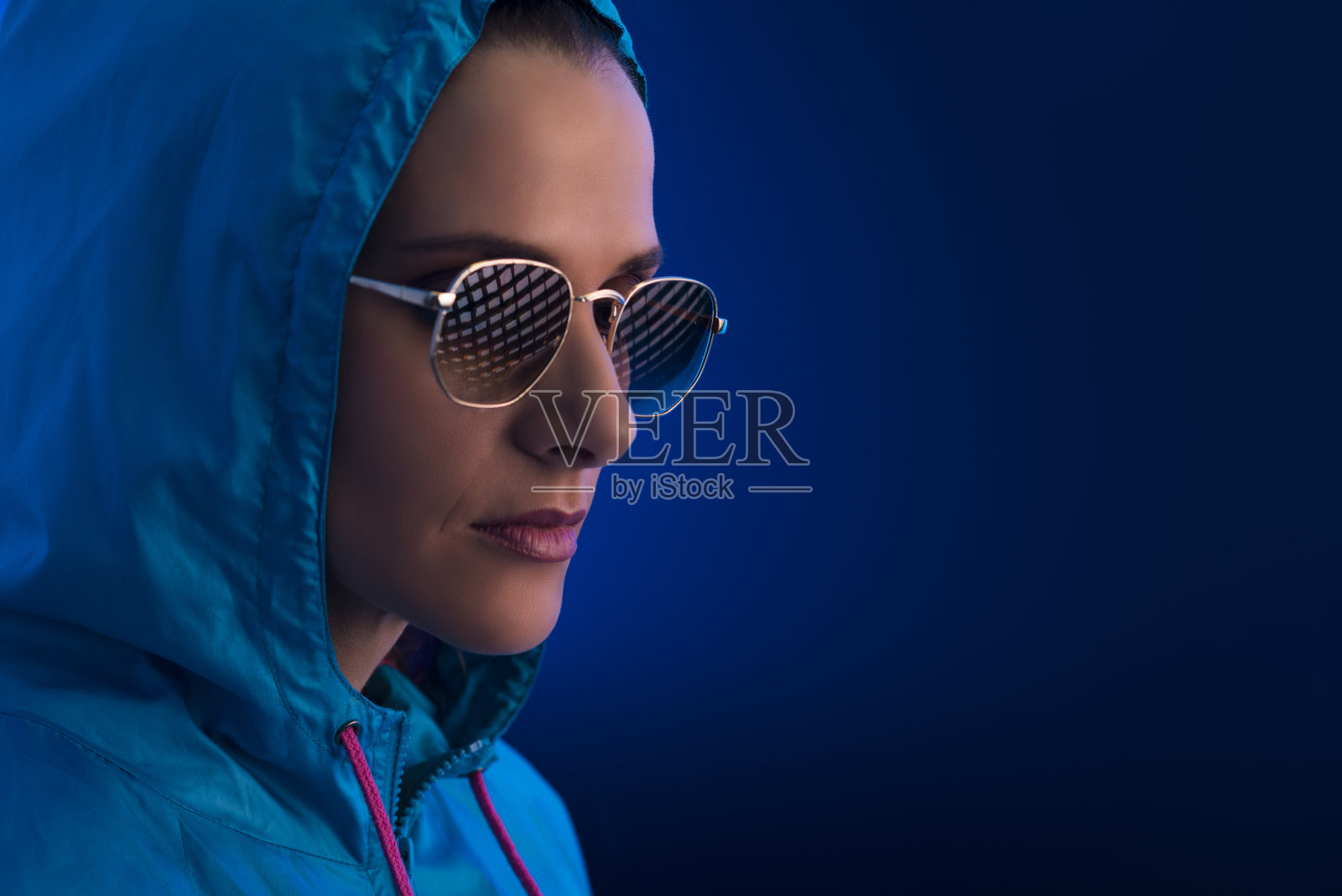一个穿着连帽和太阳镜的女人的肖像。照片摄影图片