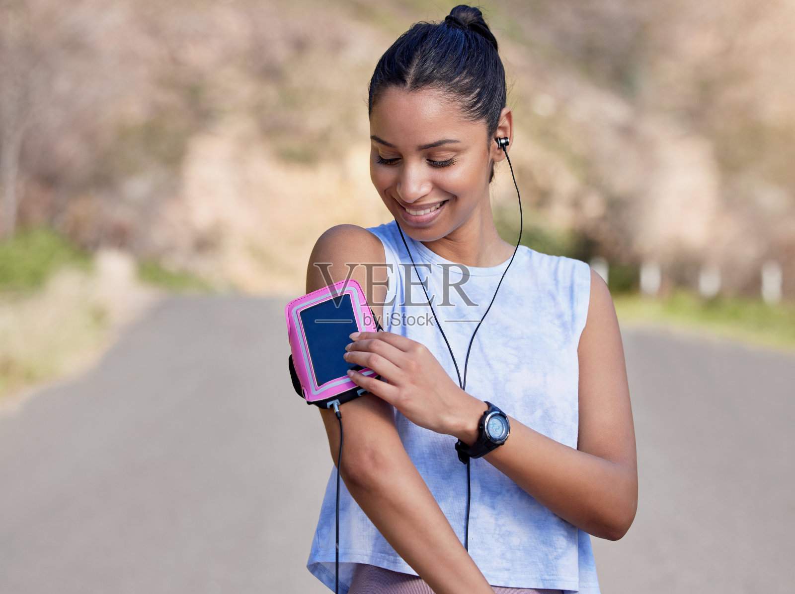 剪裁镜头的一个有吸引力的年轻女运动员设置她的播放列表之前开始她的户外跑步照片摄影图片