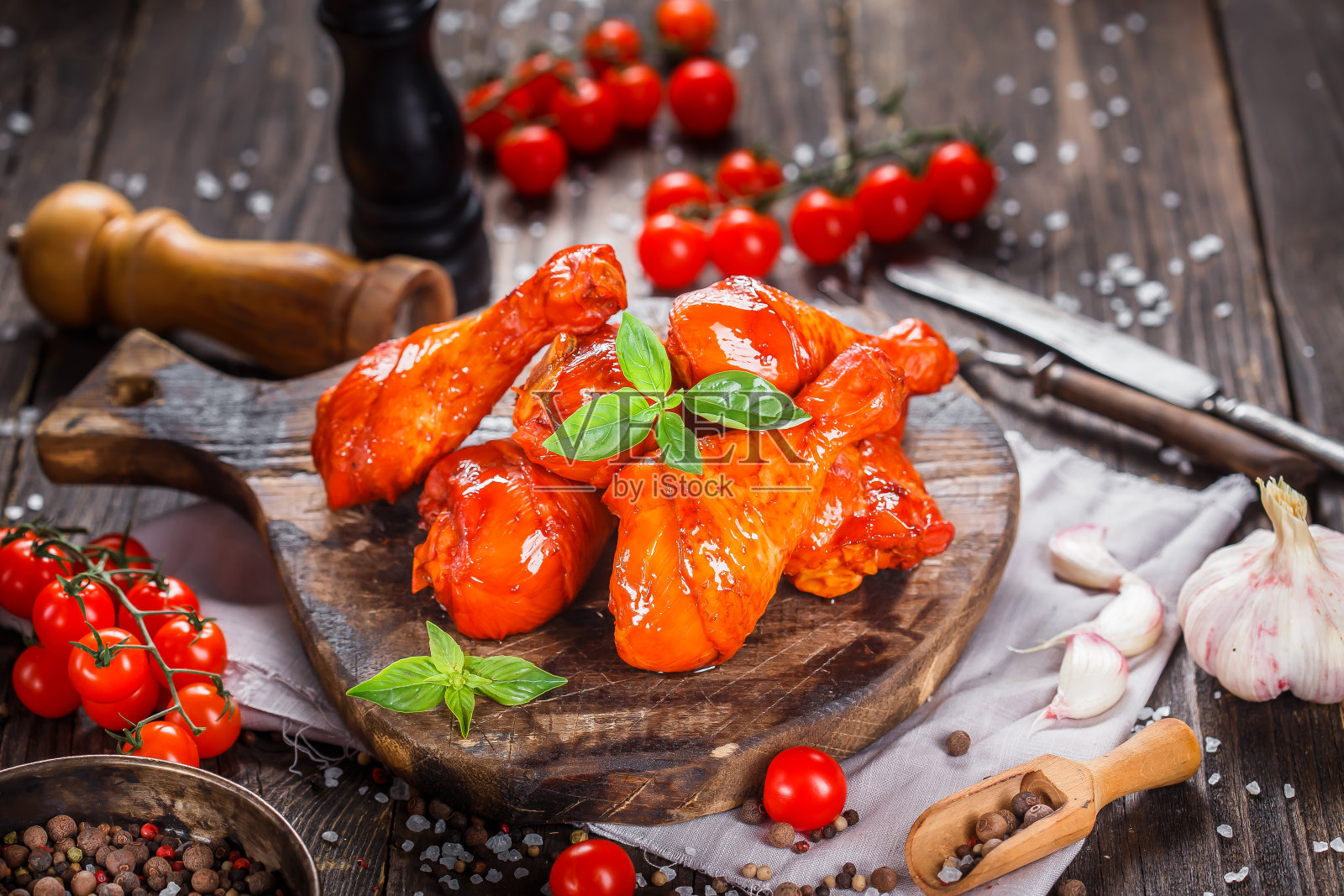 烟熏鸡翅，香料，蔬菜放在厨房砧板上，阴暗而忧郁，在黑色木制的孤立背景上，顶部照片摄影图片