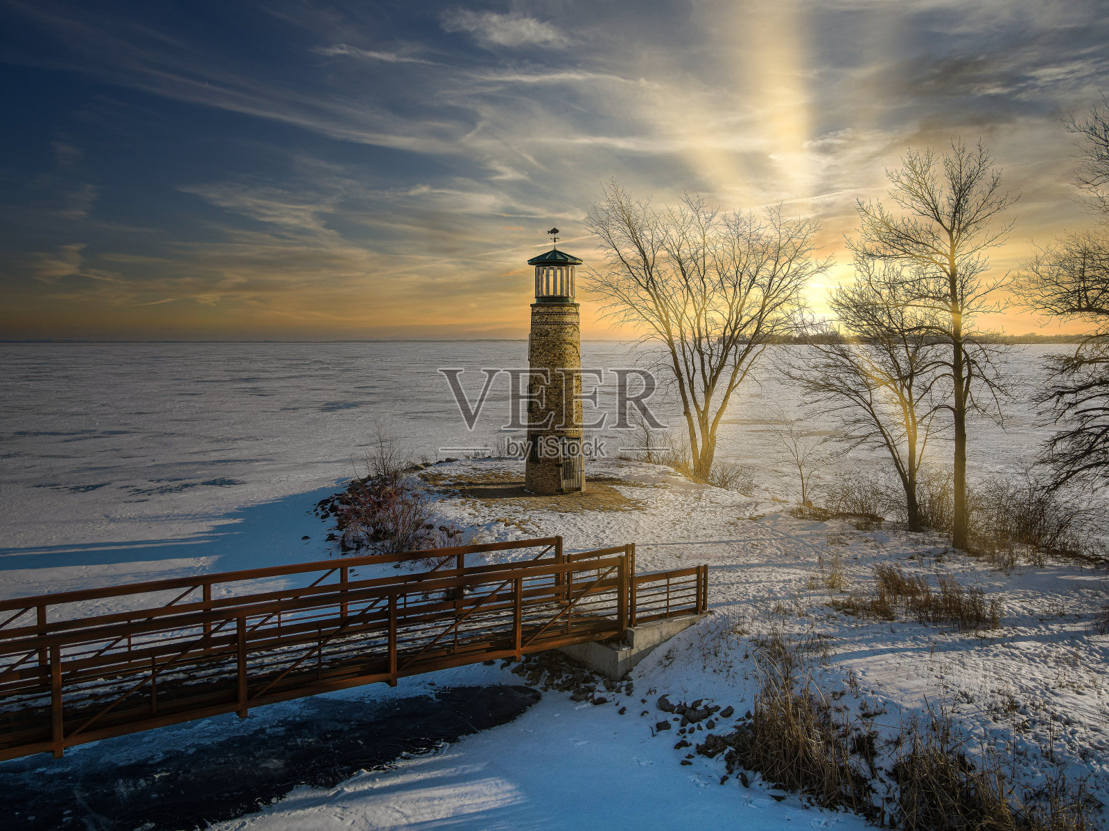 在当地的公园里，古老的灯塔仍然矗立在结冰的湖面上照片摄影图片