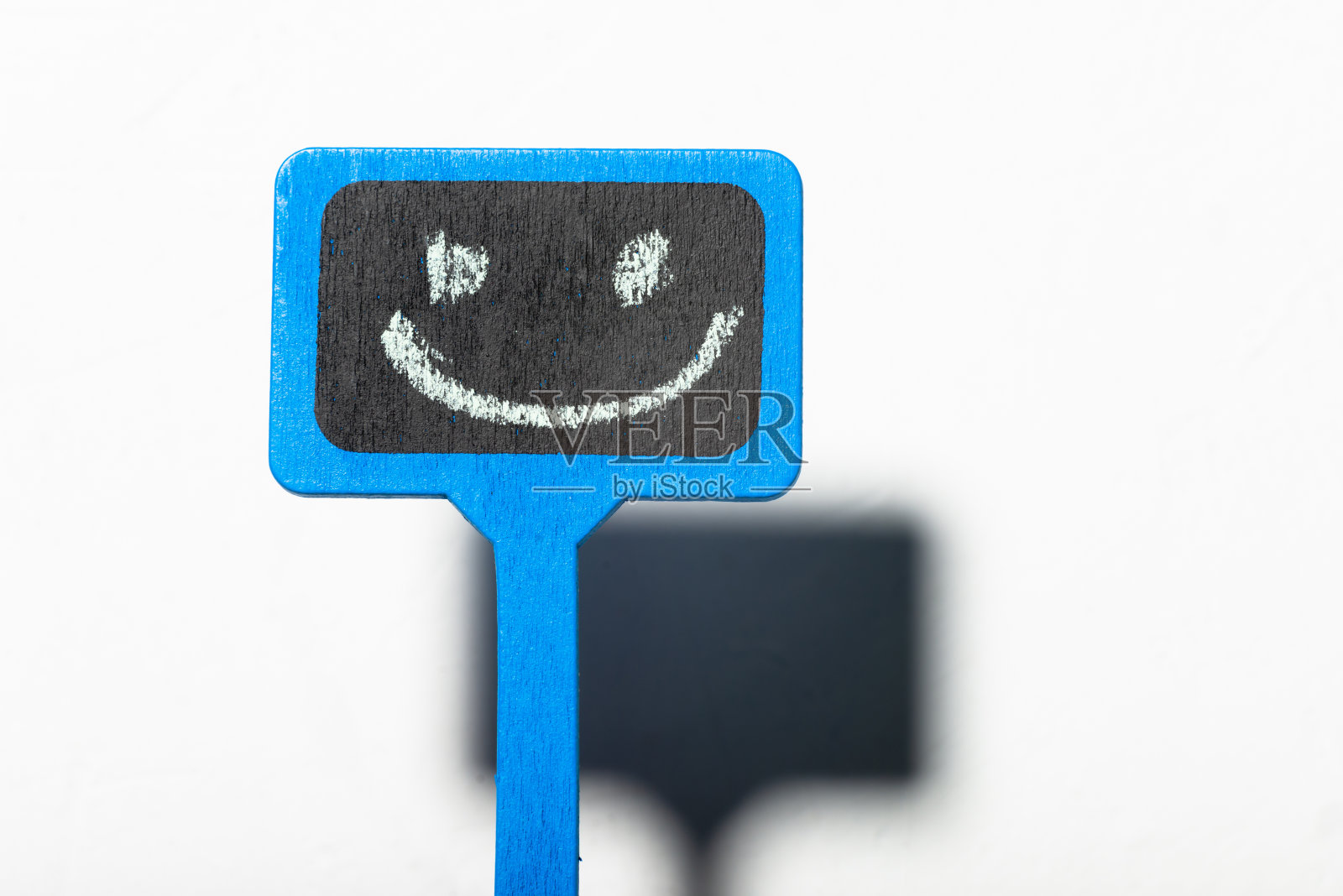 一个带笑脸的标志。蓝色的木制海报，白色的背景上有一个积极的微笑。照片摄影图片