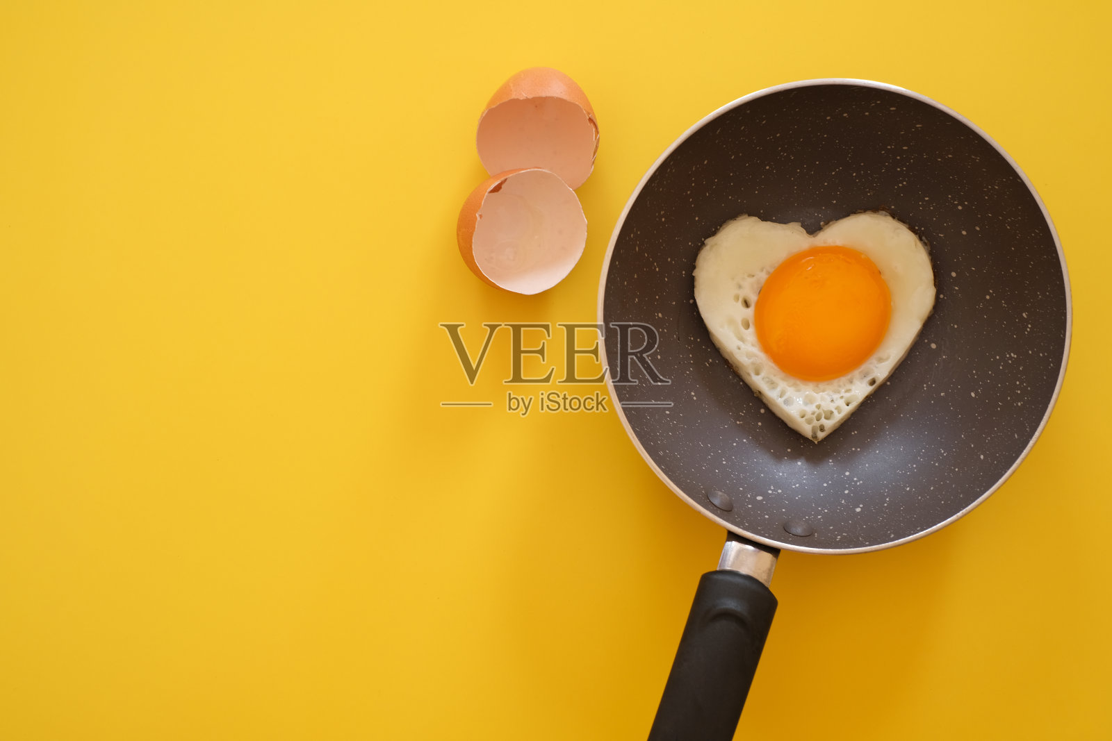 心形煎蛋，鸡蛋壳和鸡蛋在黄色的背景。前视图。健康食品的概念。文本的复制空间照片摄影图片