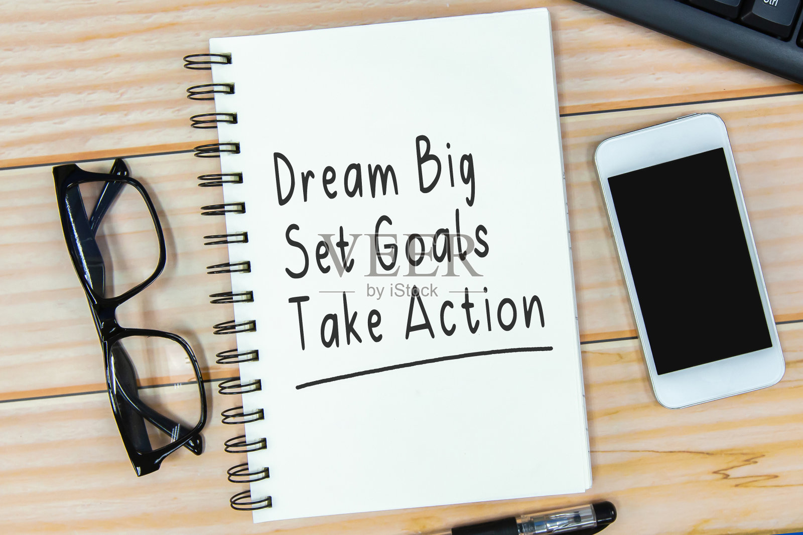 打开笔记本，文字“梦想大，设定目标，采取行动”和木制背景的眼镜。照片摄影图片