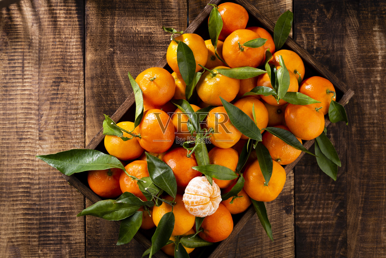 新鲜的柑橘水果或柑橘与叶子在木制盒子，俯视图照片摄影图片