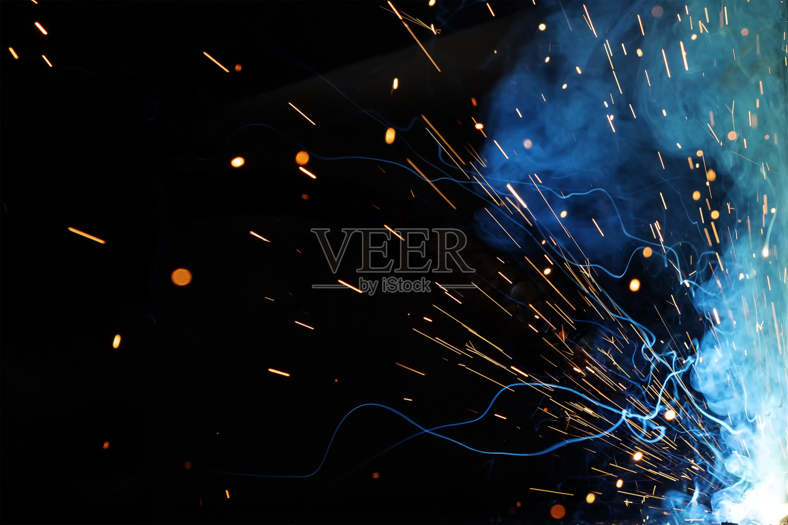 近距离观看气体金属弧焊(GMAW)过程的火花、光、散景效应和烟雾的背景。照片摄影图片