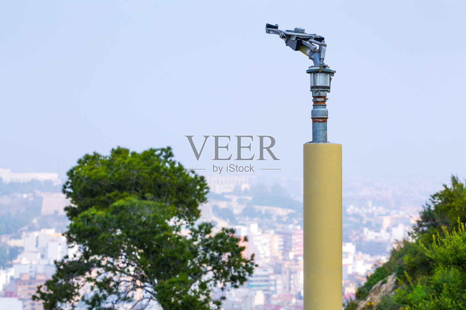 带有喷嘴阀的消防洒水喷头。在干燥和炎热的气候地区，森林或公园绿色可燃种植园的防火系统的一个重型部分。阿利坎特。西班牙。照片摄影图片