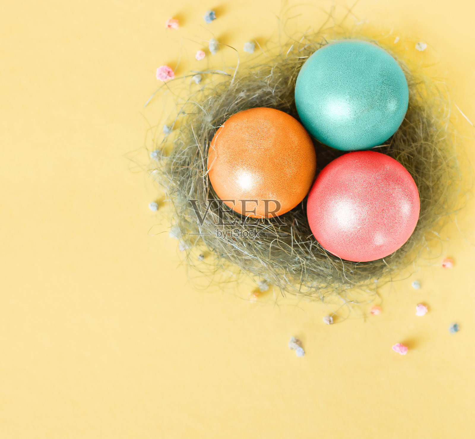 复活节彩蛋躺在黄色背景的鸟巢里照片摄影图片