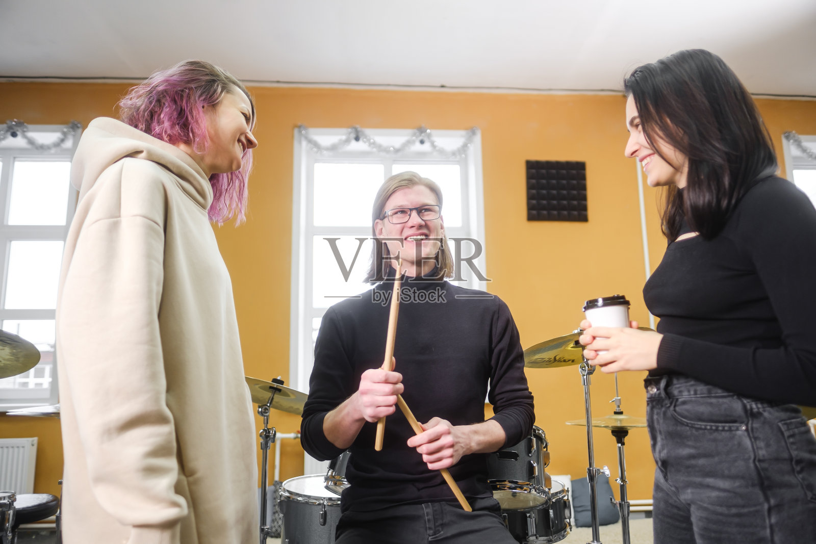 年轻的成年男女在学校学习打鼓。爱好和消遣。照片摄影图片