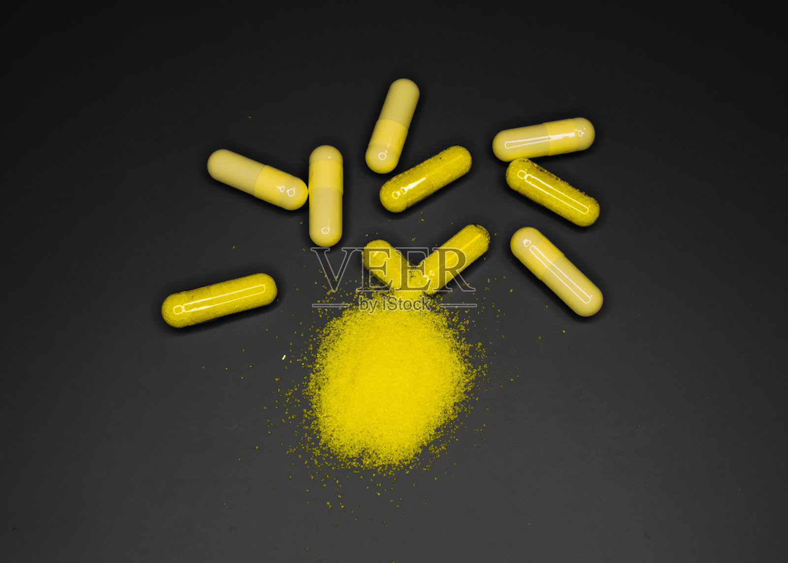 黄色胶囊药，药丸，粉末药，黑色背景照片摄影图片