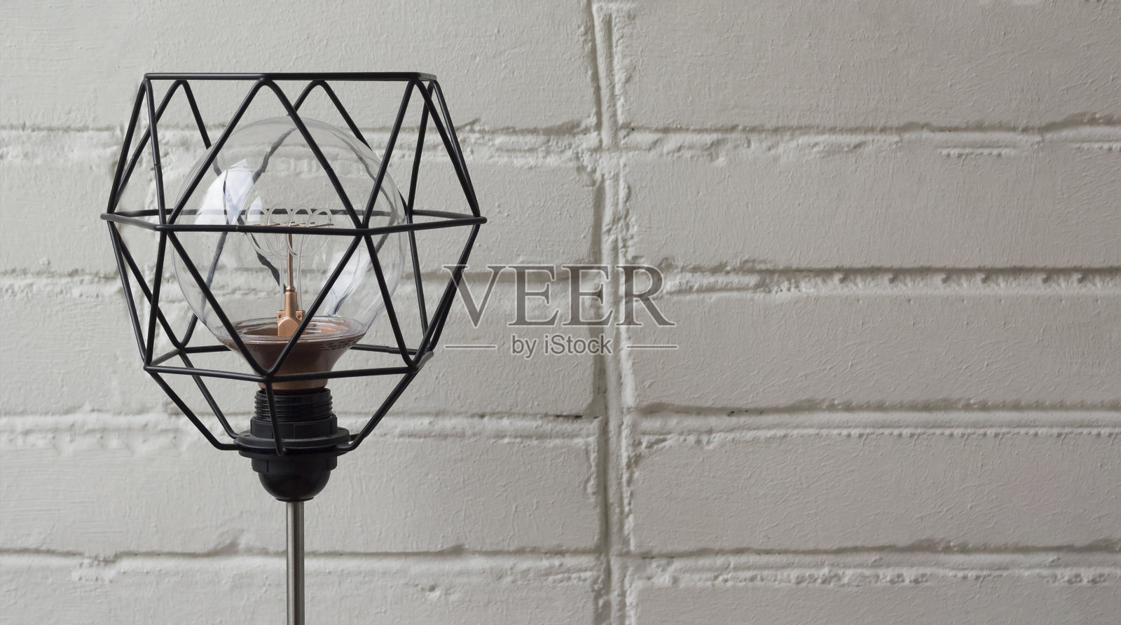 白色砖墙上有一个金属灯罩的电灯照片摄影图片
