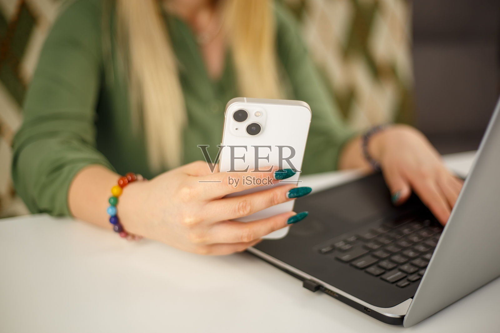 自由职业女性在锁定状态下使用新的白色电话进行在线交流。企业家人际网络与智能手机应用程序和笔记本电脑。年轻女性浏览社交媒体新闻照片摄影图片