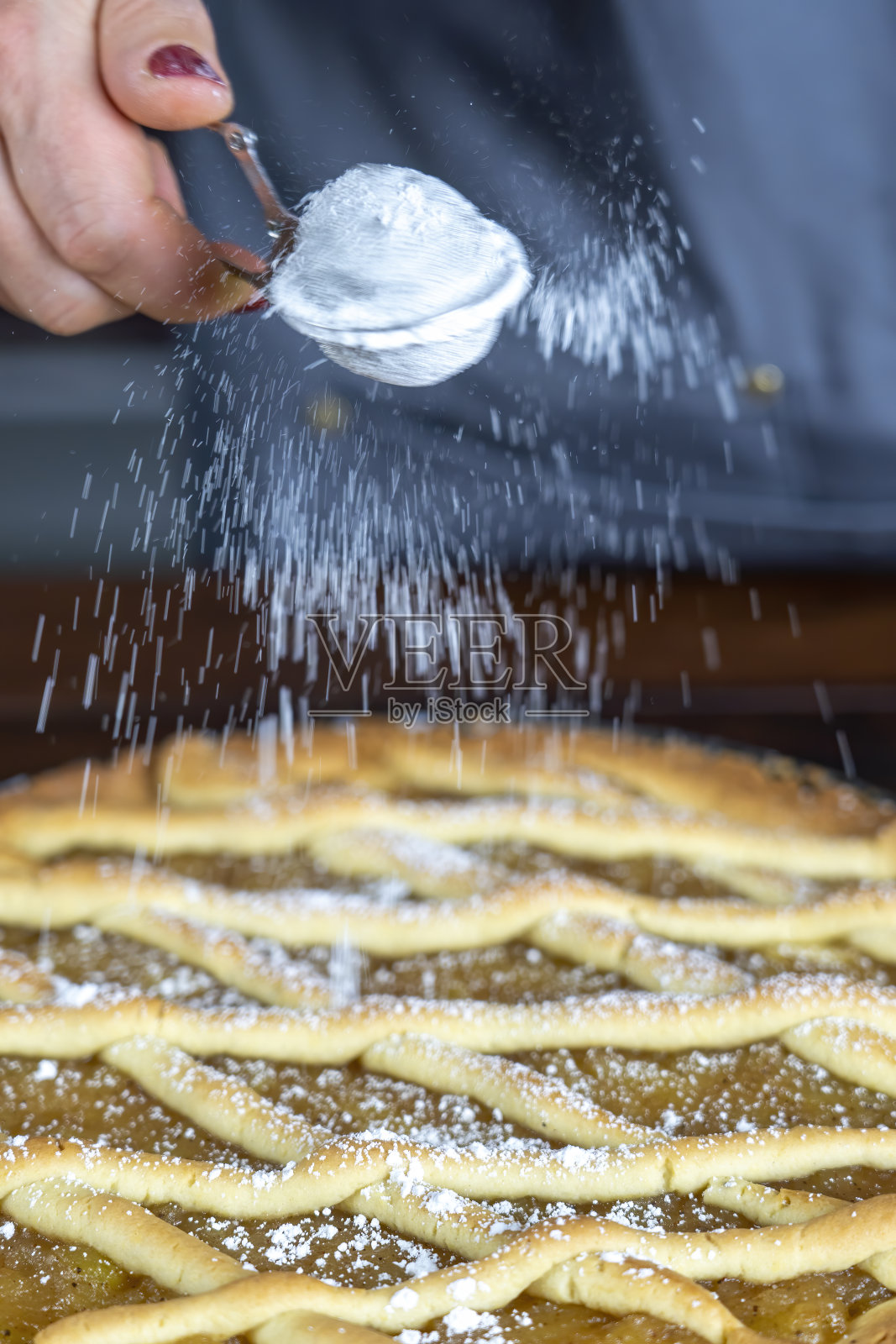 妇女准备美味的苹果挞或派大木头桌子背景。撒上糖粉。照片摄影图片
