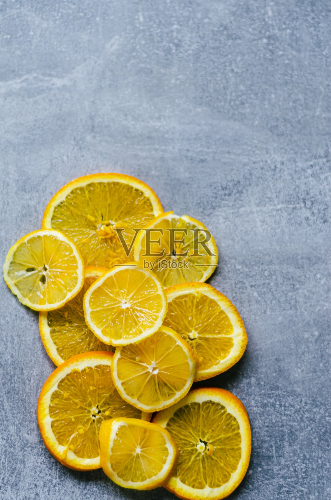 灰色背景上的橘子和柠檬片照片摄影图片